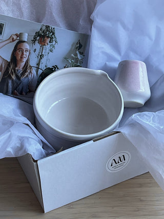 White ceramic bowl in a box with a visible brand logo in a gift box